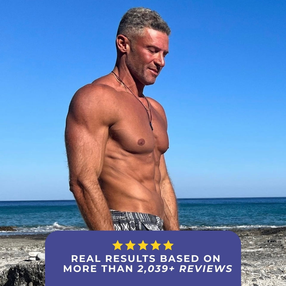 Muscular man standing on the beach with ocean in the background